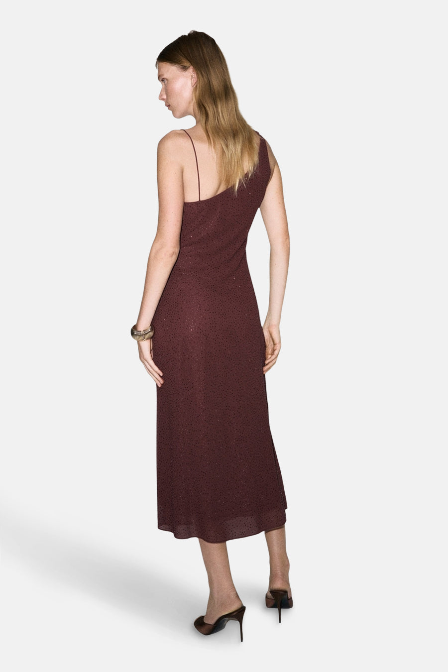 Bordeaux kleedje met lange mouwen van MANGO, met een one-shoulder halslijn en hoge hakken.
