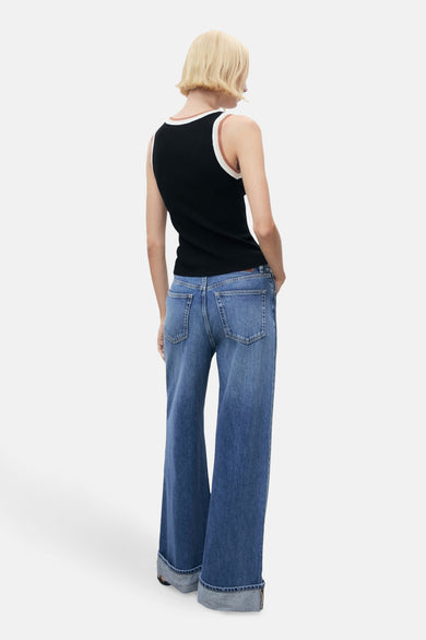 T-shirt noir de MANGO, avec des détails blancs et marrons le long de la ligne du col, associé à des jeans larges.