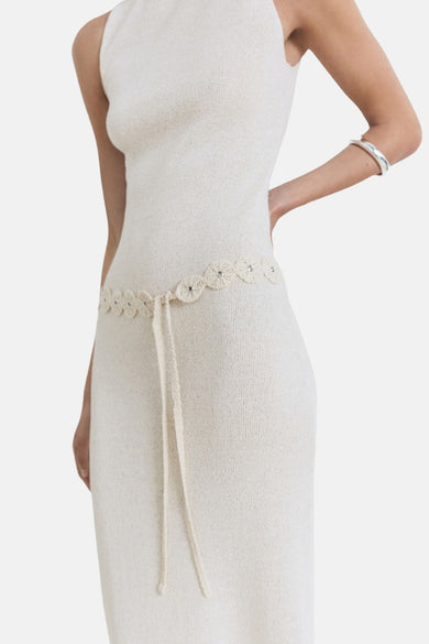 Beige kleedje zonder mouwen van MANGO, met geborduurde riem en zilveren armband.
