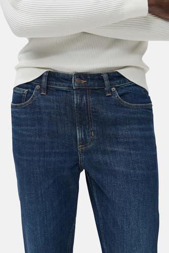 Jean tapered bleu marine de MANGO, avec une texture visible et un pull légèrement coloré.