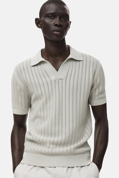 Polo gris à manches courtes de MANGO, avec un motif tricoté ouvert.