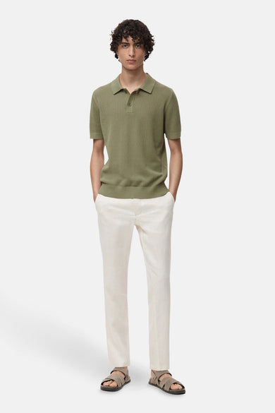 Kaki polo avec des manches courtes de MANGO, doté d'une subtile structure à côtes et porté avec un pantalon en lin et des sandales.