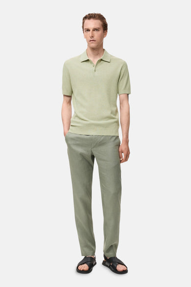 Groene polo met korte mouwen van MANGO, met een ribgebreide textuur, gedragen met een broek en sandalen.