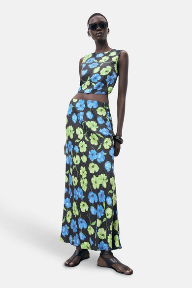 Lange multicolor rok van MANGO, met een bloemenprint en gedragen met zwarte sandalen en zonnebril.
