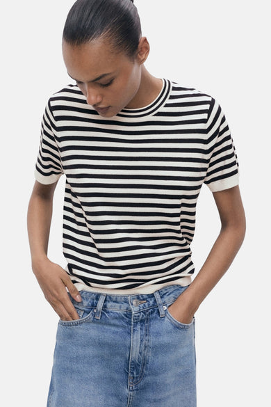 Veelkleurig T-shirt met korte mouwen van MANGO, met horizontaal gestreept patroon en gecombineerd met een blauwe jeans.
