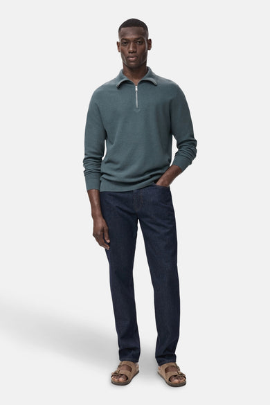 T-shirt bleu avec col montant de MANGO, associé à des jeans foncés et des sandales brunes.