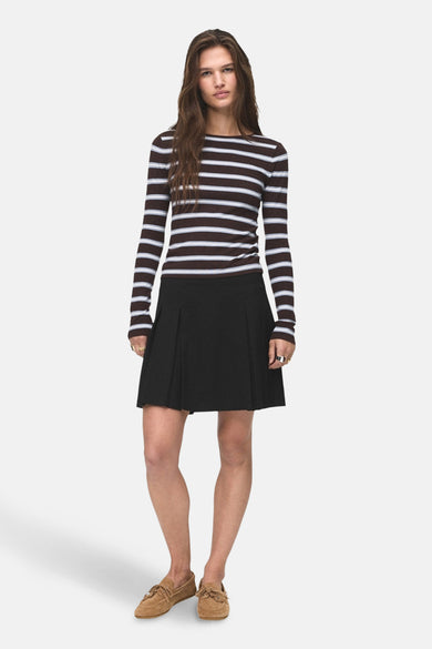 Zwarte korte rok van MANGO, gecombineerd met een gestreepte top en suède schoenen.
