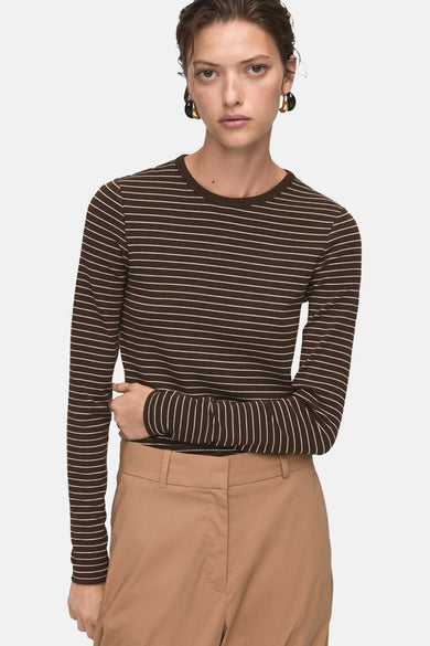 T-shirt rayé marron de MANGO, à longues manches, associé à un pantalon beige.