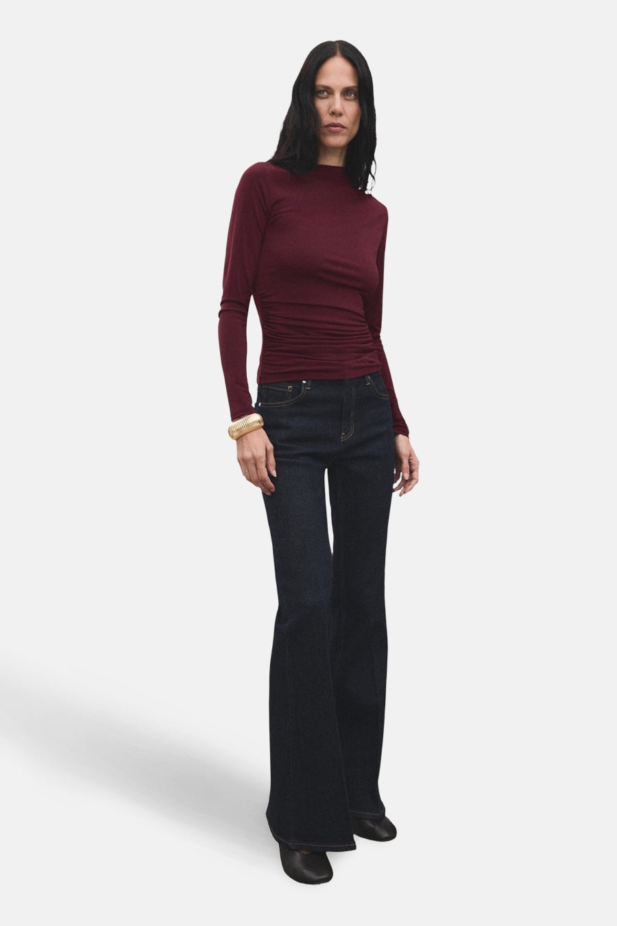 Bordeaux T-shirt met lange mouwen van MANGO, gedragen met wijde jeans en gouden armband.