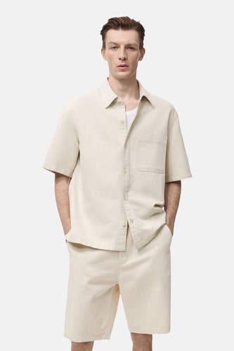 Ecru jeanshemd van MANGO, met korte mouwen en een borstzak, gedragen met een wit T-shirt.