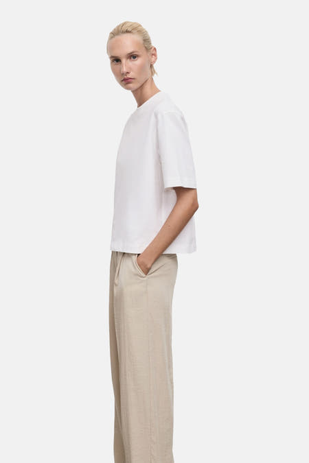T-shirt blanc à manches courtes de MANGO, porté avec un pantalon beige, vue arrière.
