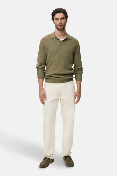 T-shirt kaki MANGO avec col rond, manches longues, associé à un pantalon blanc et des chaussures marron.