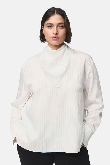 Witte blouse met lange mouwen van MANGO, met subtiele verticale strepen en een losse pasvorm.
