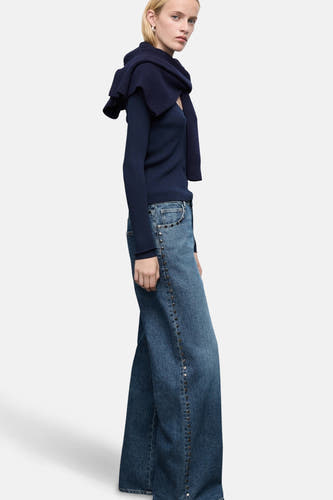 Donkerblauwe denim wijde jeans van MANGO, afgewerkt met studs langs de zijkant, gedragen met een donkerblauwe top.