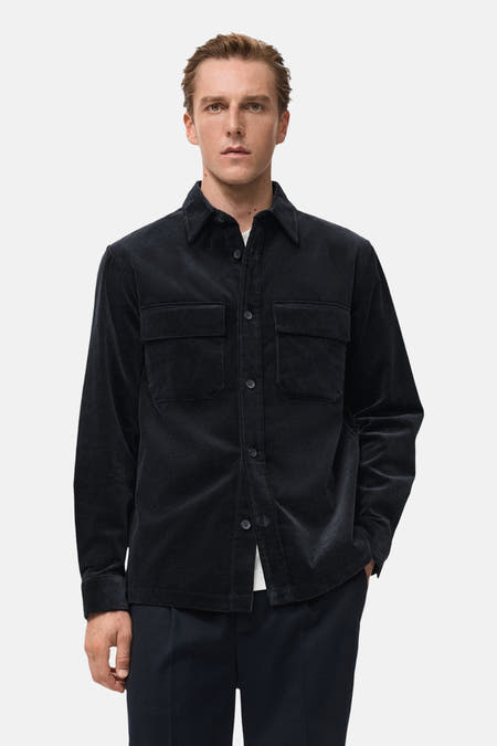 Veste courte bleue de MANGO, à manches longues et deux poches poitrine.