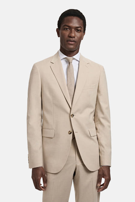 Beige blazer van MANGO, gedragen met een wit overhemd en bijpassende das.
