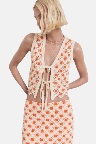 Korte, multicolor rok van MANGO, met een gehaakt patroon van oranje bloemen en een bijpassende top.
