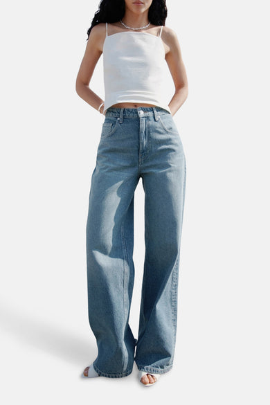 Wijde jeans in mid blue denim van MANGO, met een witte top en sandalen.
