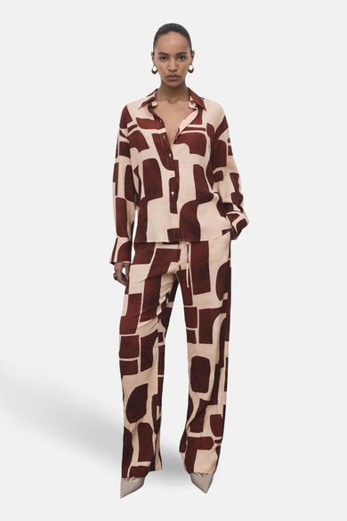 Multikleurig overhemd met lange mouwen van MANGO, met een abstract geometrisch patroon, gedragen met bijpassende broek.