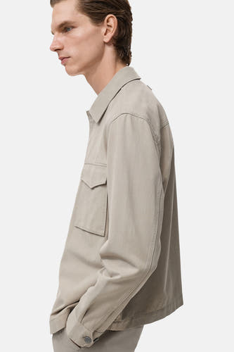 Beige overhemd met lange mouwen van MANGO, met opgestikte zak en knoopsluiting, in zijaanzicht.
