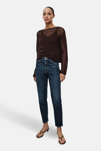 Donkerblauwe mom jeans van MANGO, gecombineerd met een bruine top en sandalen met hak.