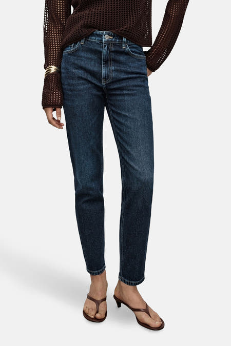 Jean mom bleu marine de MANGO, porté avec un haut tricoté marron et des sandales marron.