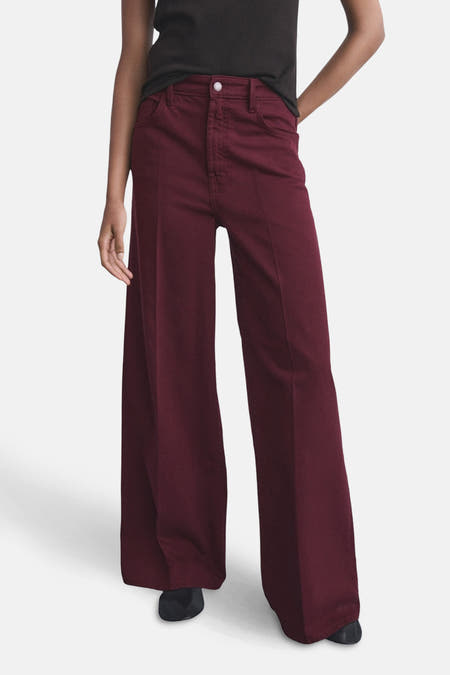 Jean de couleur bordeaux de MANGO, avec des jambes larges et une ceinture à bouton.