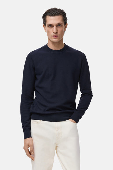 T-shirt bleu avec col rond de MANGO, porté avec un pantalon blanc.