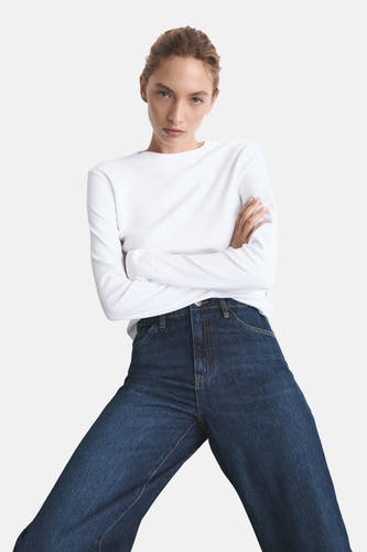 Jean bleu marine large de MANGO, associé à un t-shirt blanc à manches longues.