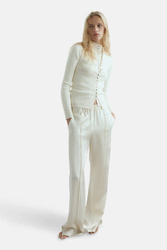 Beige gilet van MANGO, gedragen met bijpassende broek en gebreide top met lange mouwen.
