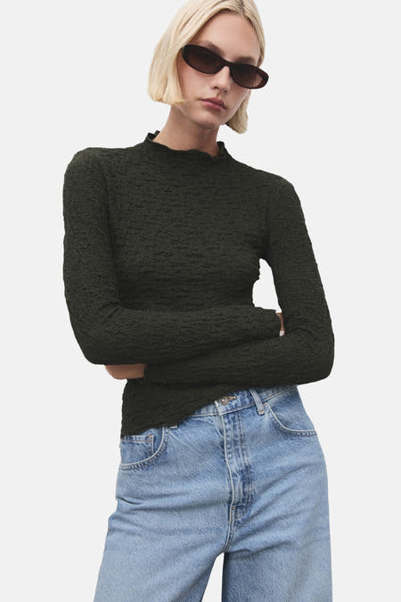 Khaki T-shirt met lange mouwen van MANGO, met een gekreukte textuur, gecombineerd met een losse jeans.