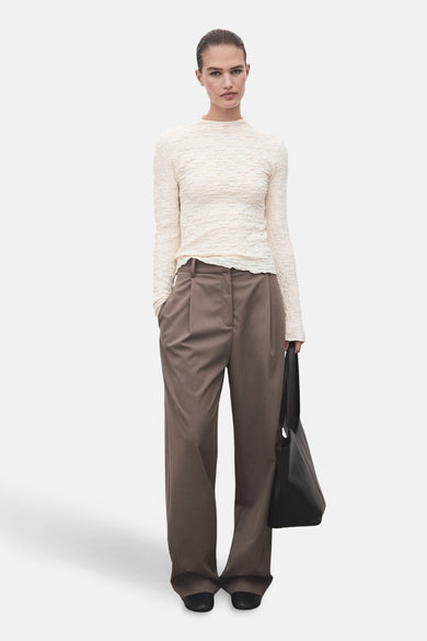 Beige T-shirt met lange mouwen van MANGO, met een geplooide textuur.
