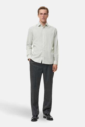 Groen overhemd met lange mouwen van MANGO, gestreept patroon en gedragen met een grijze pantalon en zwarte schoenen.