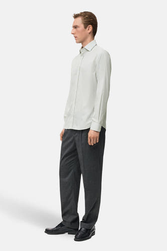 Chemise verte à manches longues de MANGO, portée avec un pantalon gris et des chaussures en cuir noires.