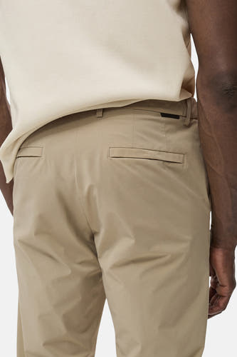 Beige broek van MANGO, met achterzakken en een subtiele textuur, onderdeel van een outfit met een beige top.

