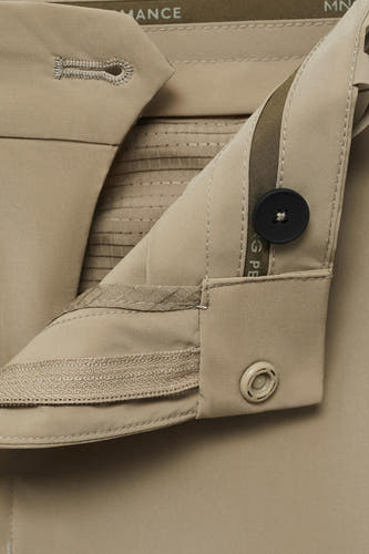 Beige broek van MANGO met knoop- en ritssluiting, cropped close-up.
