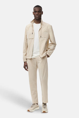 Ecru broek van MANGO, met een casual model en gecombineerd met een wit T-shirt en bijpassende jas.