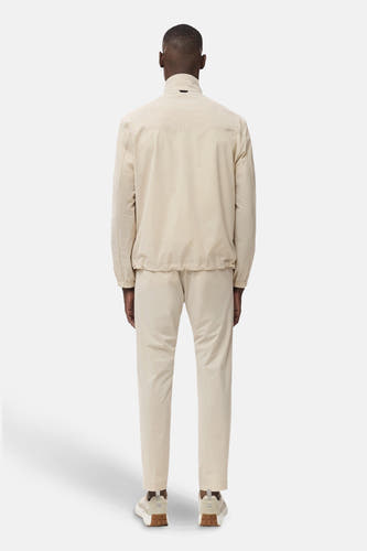 Ecru broek van MANGO, gezien van achteren, met bijpassend jasje en witte sneakers.
