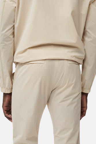Ecru broek van MANGO, achterkant, met steekzakken aan de achterkant en lange pijpen.