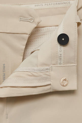 Ecru broek van MANGO Performance met een knoopsluiting en een ritsdetail.
