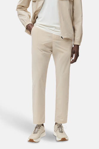 Ecru broek van MANGO, gedragen met een wit t-shirt en beige jas, en bijpassende schoenen.

