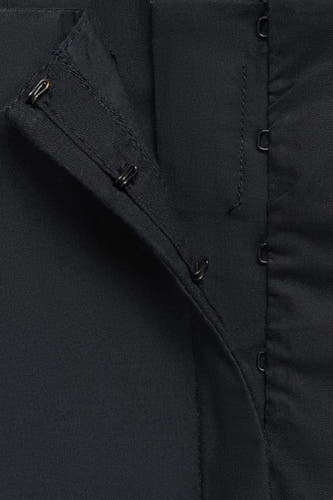 Zwarte top van MANGO met haak- en oogsluiting, close-up.
