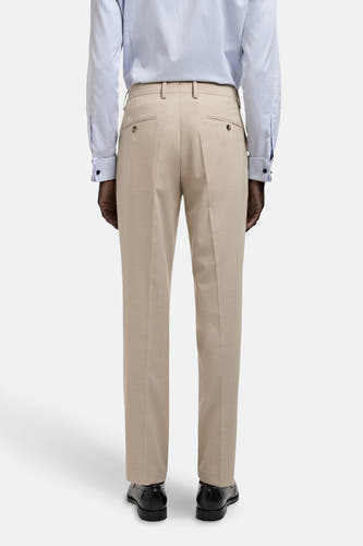 Beige kostuumbroek van MANGO, met knoopzakken aan de achterkant, gedragen met een lichtblauw overhemd en zwarte schoenen.