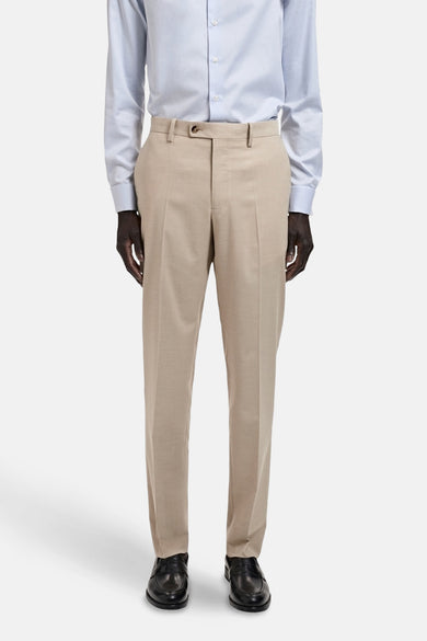 Beige kostuumbroek van MANGO, met persplooien en een knoopsluiting, gecombineerd met een lichtblauw overhemd en zwarte schoenen.
