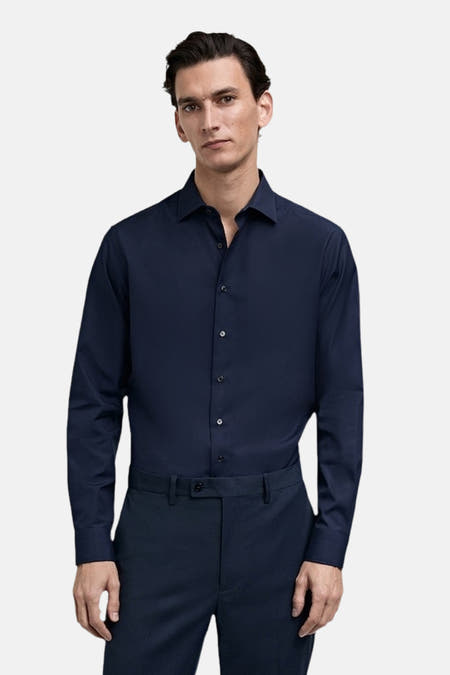 Blauw overhemd met lange mouwen van MANGO, gedragen met donkere pantalon.