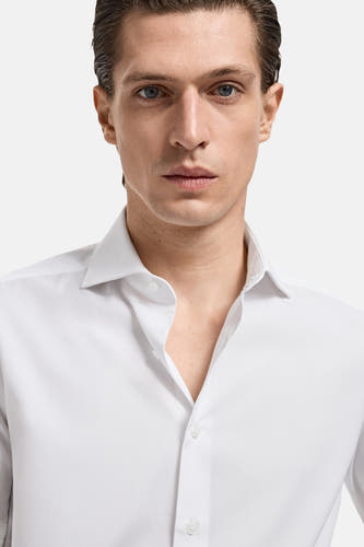 Wit overhemd met lange mouwen van MANGO, gedragen door een man met een open boord.