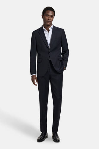 Blauwe blazer van MANGO, gedragen met een wit overhemd en zwarte schoenen, staand vooraanzicht.
