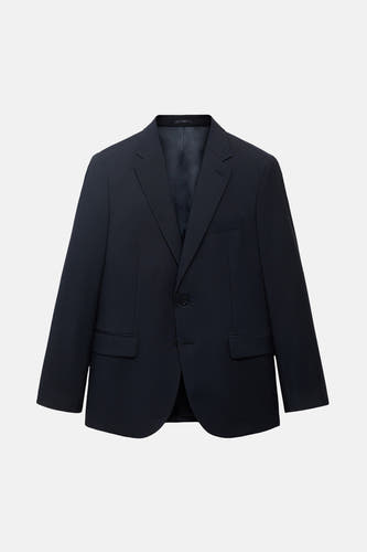 Blauwe blazer van MANGO, met een enkele knoopsluiting en paspelzakken, op een witte achtergrond.
