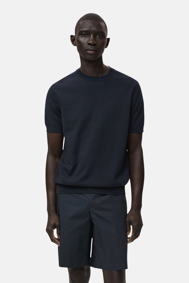 Blauw T-shirt met korte mouwen van MANGO, gedragen met donkerblauwe shorts, tegen een witte achtergrond.
