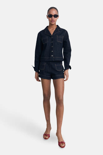 Veste en jeans bleu marine de MANGO, avec longues manches, fermeture à boutons et poches brodées.